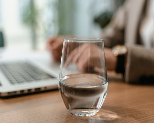 Vaso de agua en un escritorio de trabajo